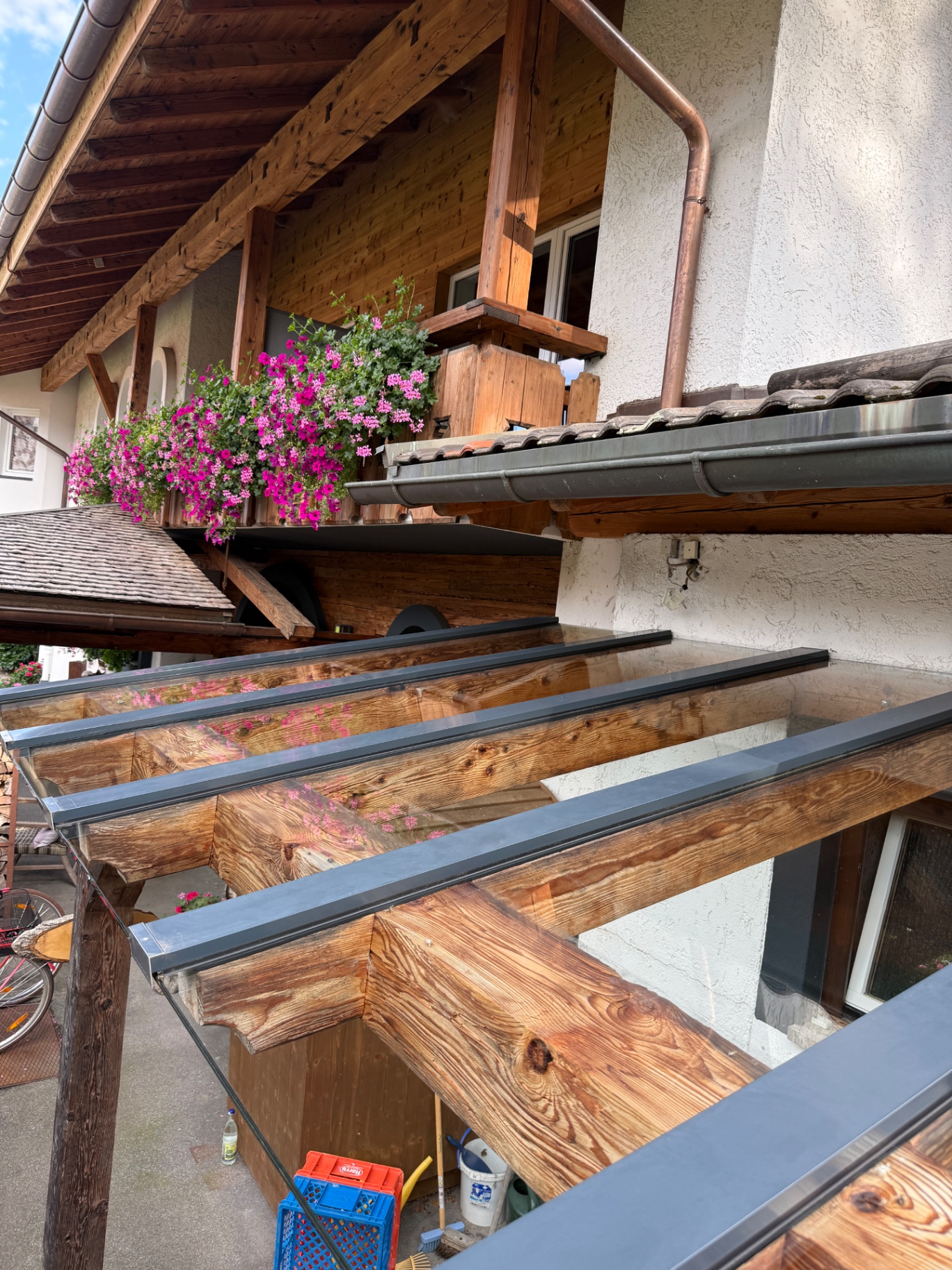 Glasdach-Vordach aus Holz und Metall nach der Reinigung