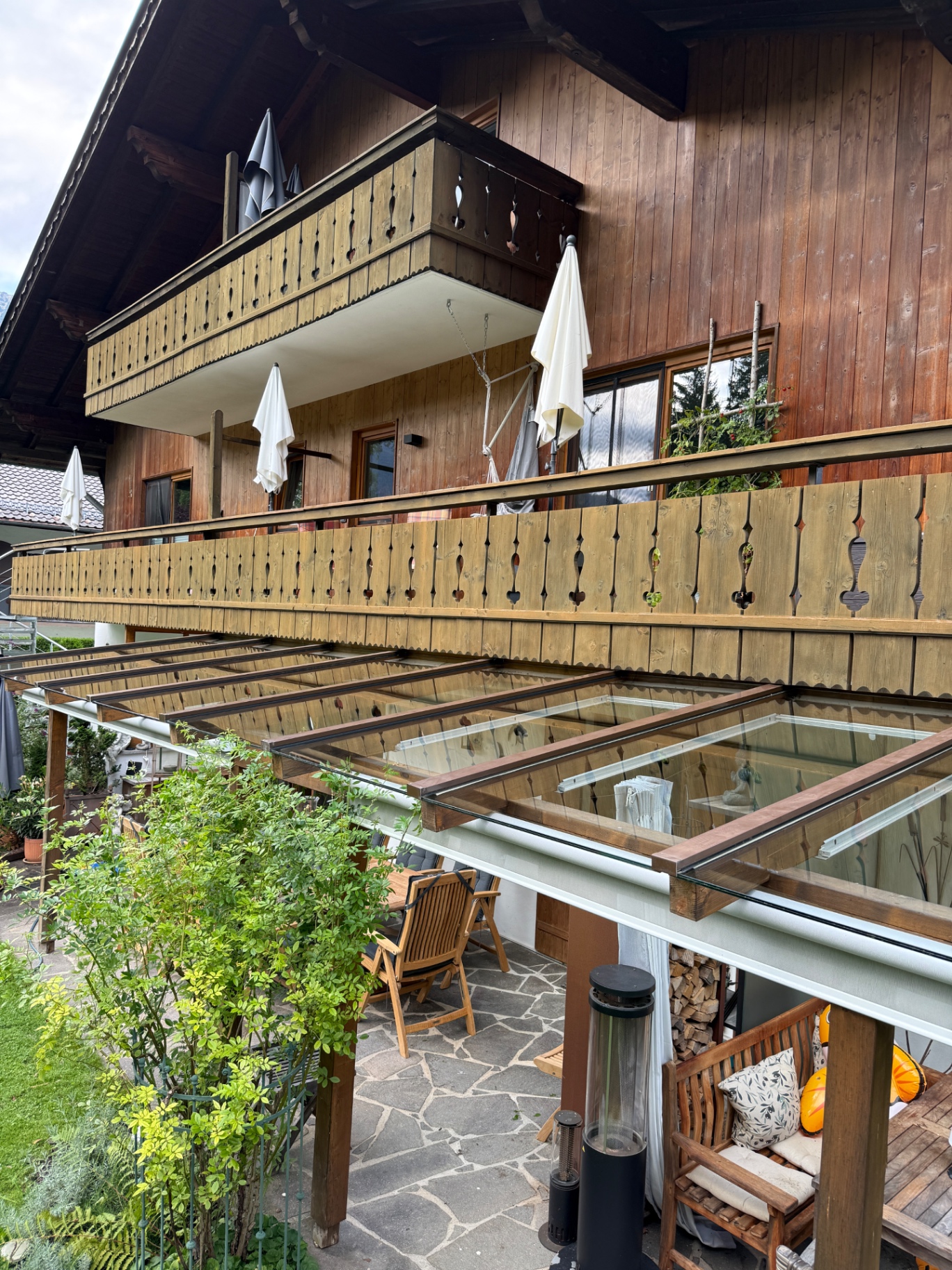 Überdachte Terrasse mit Glasdach und Holzgeländer
